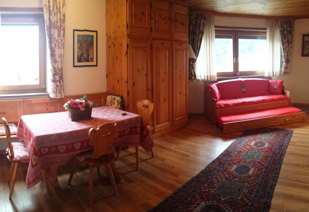 科尔福索Supermountainski Colfosco的客厅配有桌子和红色沙发