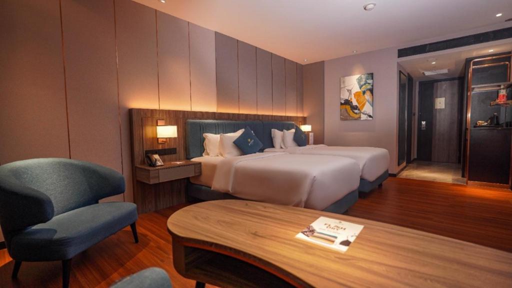 沙马林达FUGO Hotel Samarinda的配有床、椅子和桌子的酒店客房
