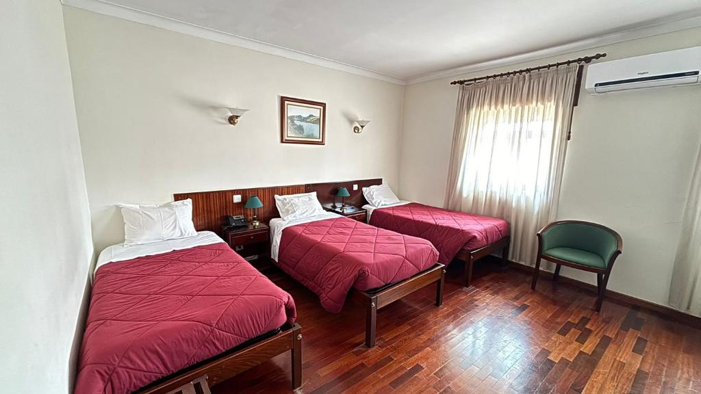 莫加多鲁Hotel Trindade Coelho的酒店客房,配有两张床和椅子