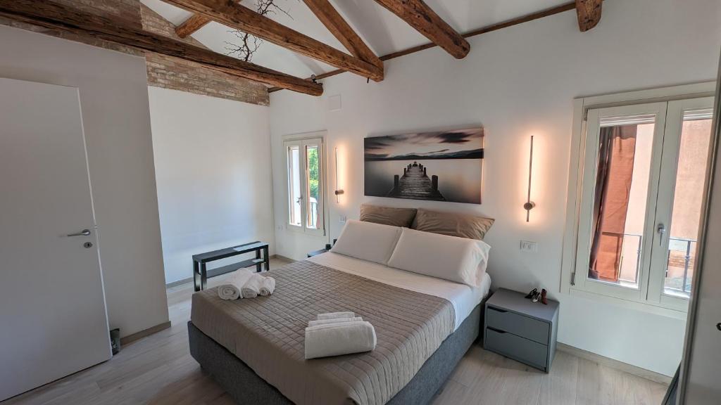 威尼斯丽都Casa Rosabianca - Ristrutturata的一间带一张大床的卧室,位于带窗户的房间内