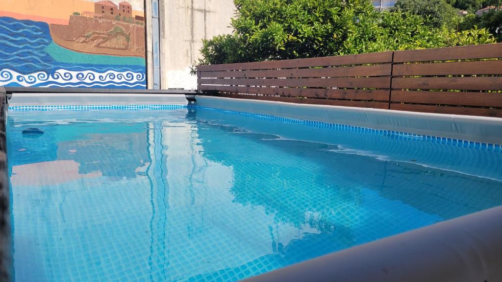 乌尔齐尼Hostel Center的一个带长凳和蓝色海水的游泳池