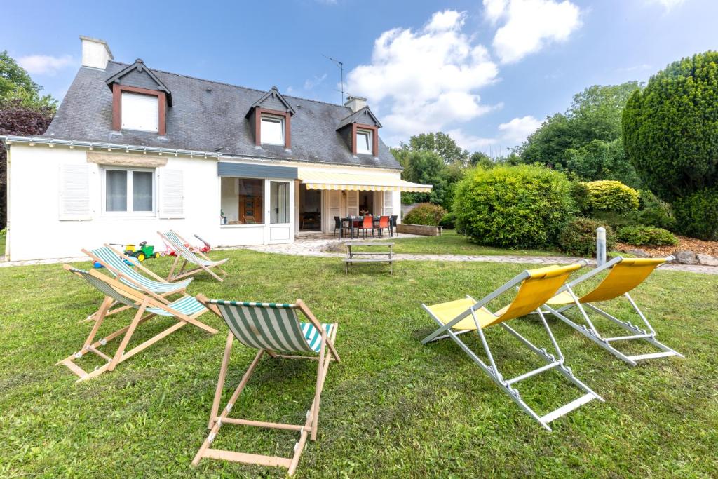 阿拉东Villa au calme absolu - à 200 m du Golfe的坐在房子前面的草上一组椅子