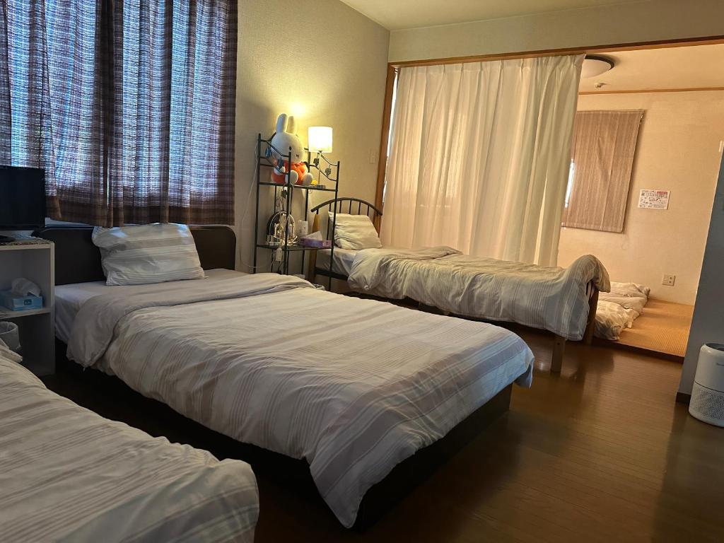 神户Private Inn Bambee的酒店客房设有三张床和窗户。