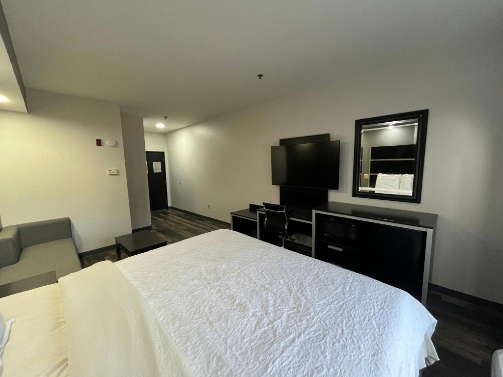 KennettEcono lodge Kennett的卧室配有白色的床和电视。