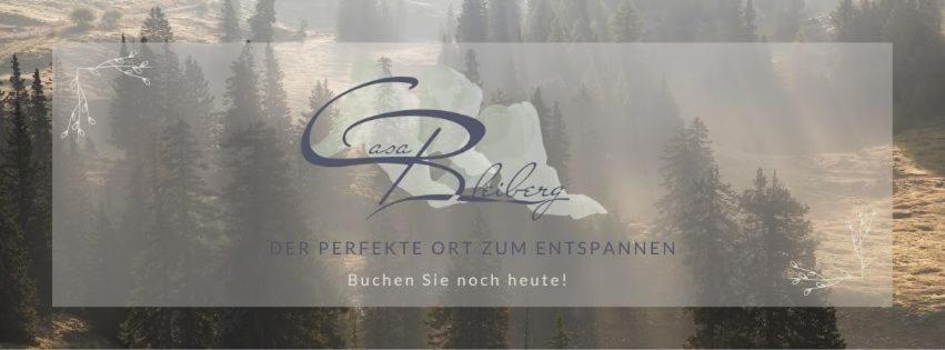 巴特布莱贝格CasaBleiberg - Garten Apartment - Naturpark Dobratsch的树后窗上的标志