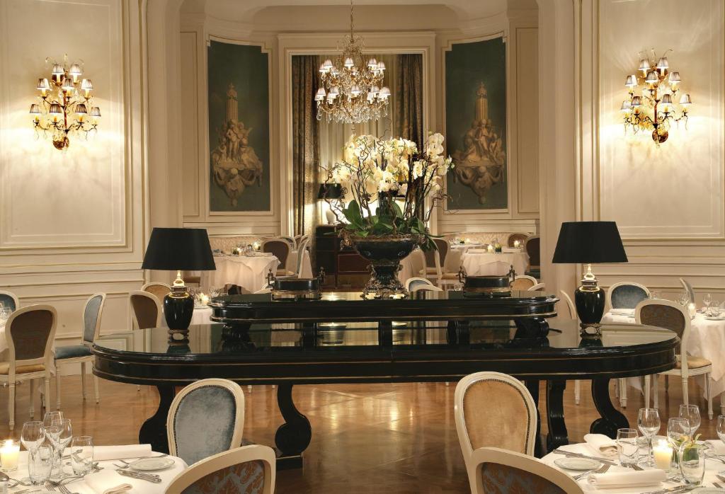 拉沙佩勒InterContinental Hotels Chantilly Chateau Mont Royal, an IHG Hotel的用餐室配有桌椅和吊灯。