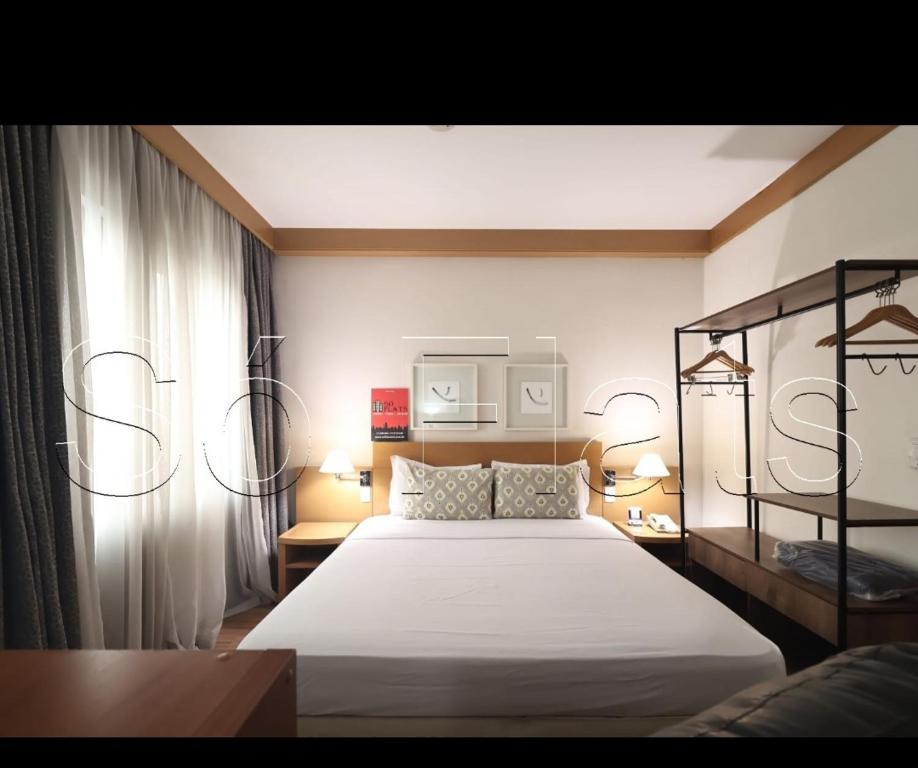 圣保罗Tatuapé flat services, ótima localização的一间卧室配有一张大床和两盏灯。