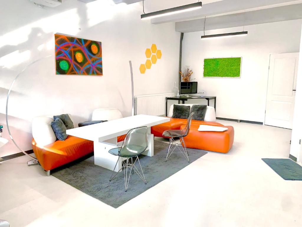 莱顿Design Family Apartment in Leiden Center 6p & baby的客厅配有橙色椅子和白色桌子