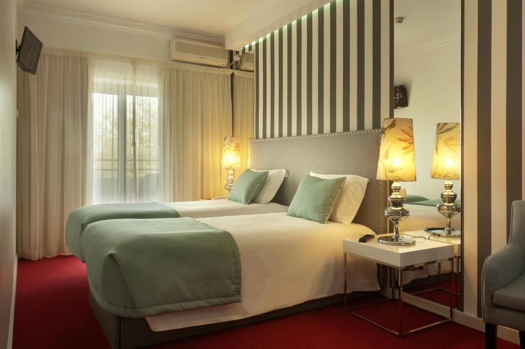 法蒂玛拉古阿多斯帕斯陀林豪斯酒店的酒店客房设有一张大床和一张桌子。