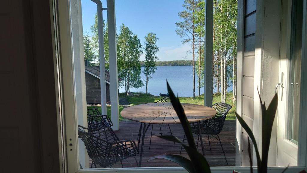 TaivalkoskiHanhi Linna的湖景庭院配有桌椅