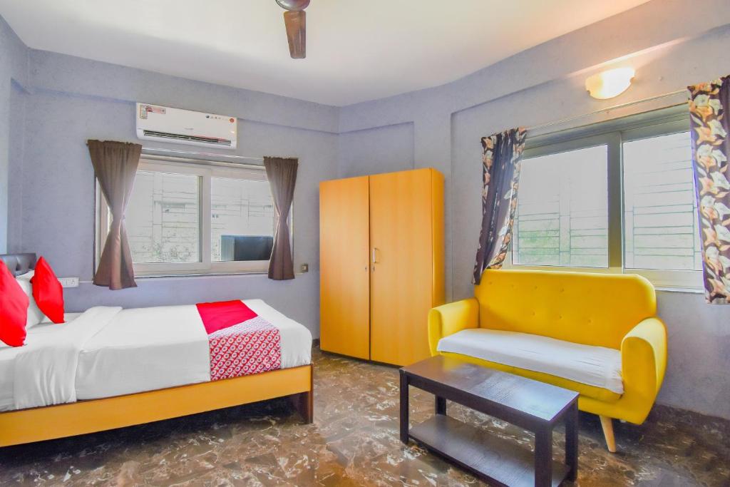 加尔各答Super OYO Krishna Guest House的卧室配有床、椅子和窗户。