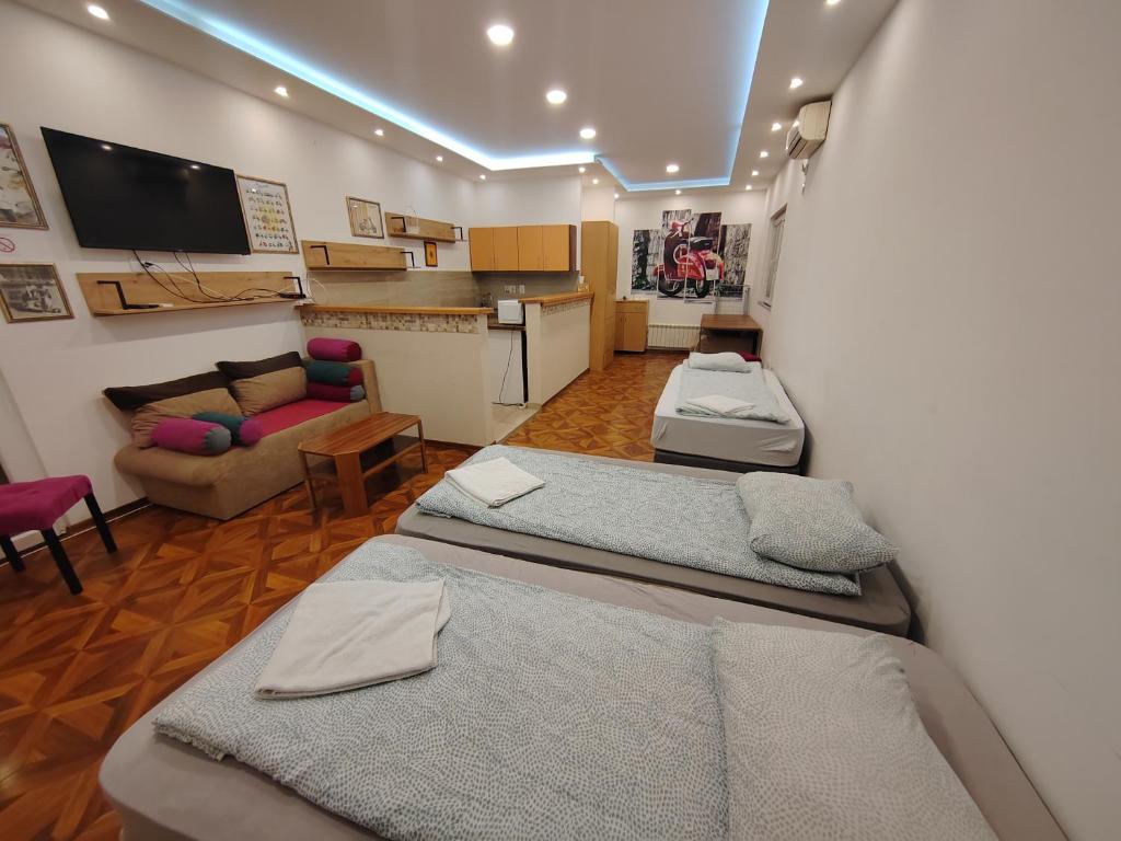 贝尔格莱德MAGENTA Apartments的带三张床的房间和客厅