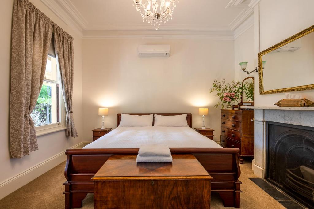瑟尔Bon Accord Luxury Accommodation的一间卧室设有一张大床和一个壁炉