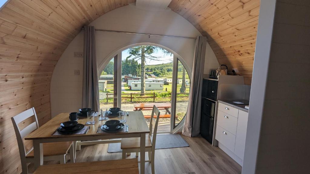 White BridgeGlengoulandie Glamping Pods的厨房以及带桌椅的用餐室。