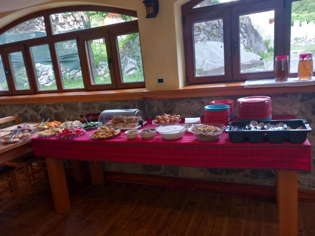瓦勒博内Hostel Quku i Valbones的桌子上装满食物的桌子,窗户