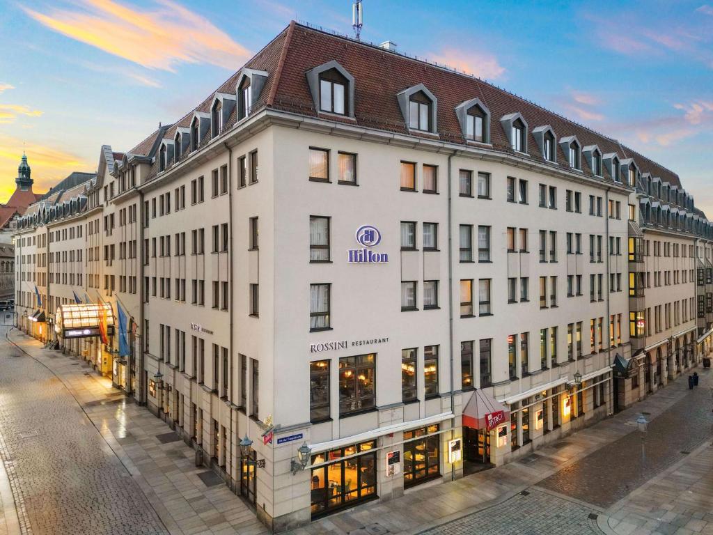 德累斯顿Hilton Dresden an der Frauenkirche的白色的大建筑,带有棕色的屋顶