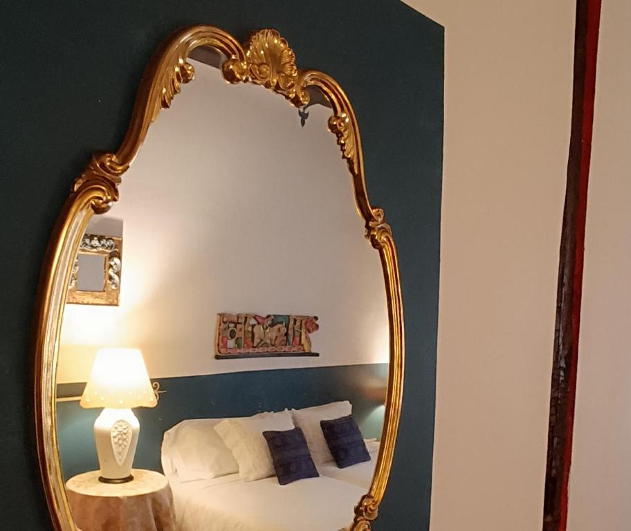纳瓦雷特Peregrinando, pensión con encanto的卧室里的金色镜子,床