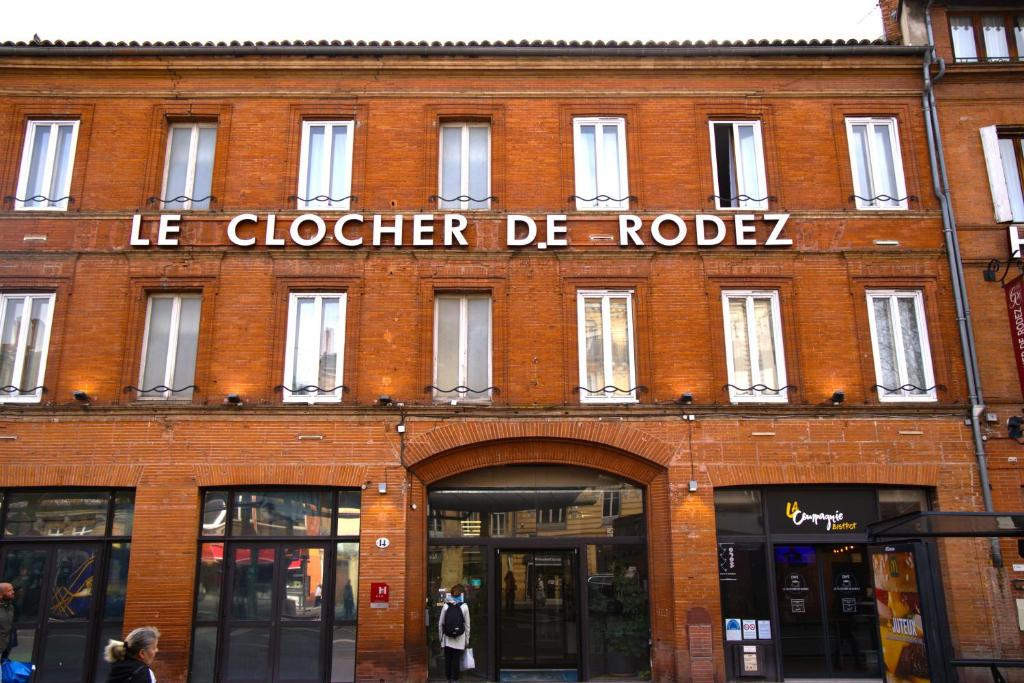 图卢兹Le Clocher de Rodez Centre Gare的红砖建筑,上面有标志