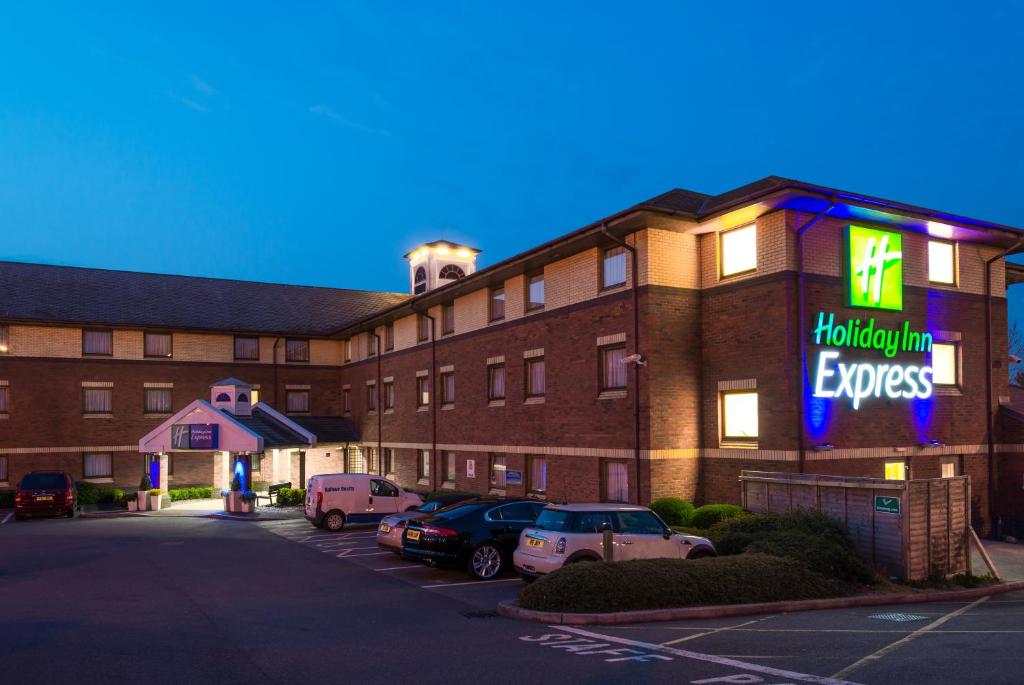 埃克塞特Holiday Inn Express Exeter East, an IHG Hotel的停车场内有车辆的旅馆