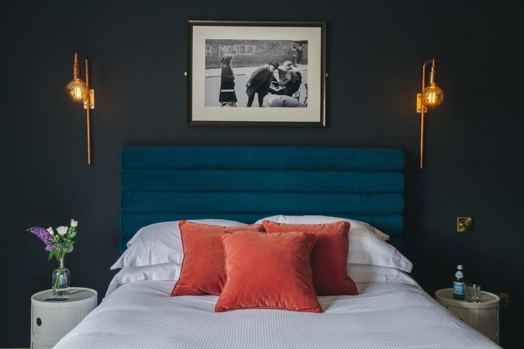 牛津烧烤客房公寓的一间卧室配有蓝色床头板和一张带枕头的床