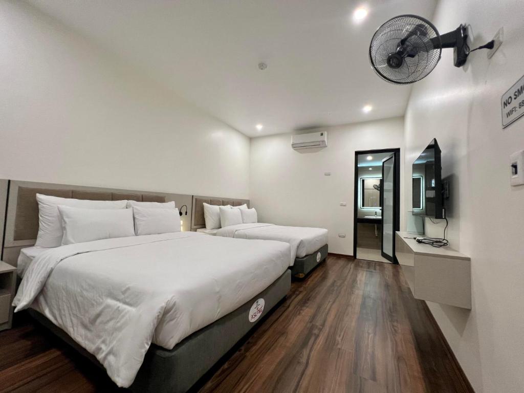 河内Grand Dragon Noi Bai Hotel的酒店客房,设有两张床和镜子
