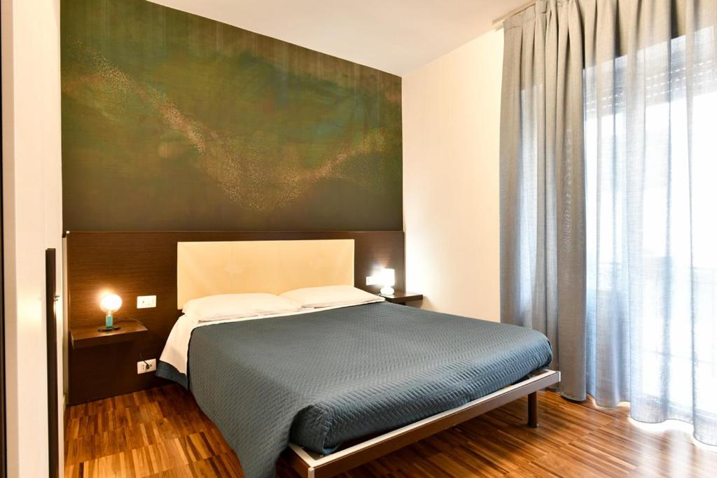 马泰拉唐娜爱莲住宿加早餐酒店的卧室配有一张床,墙上挂有绘画作品