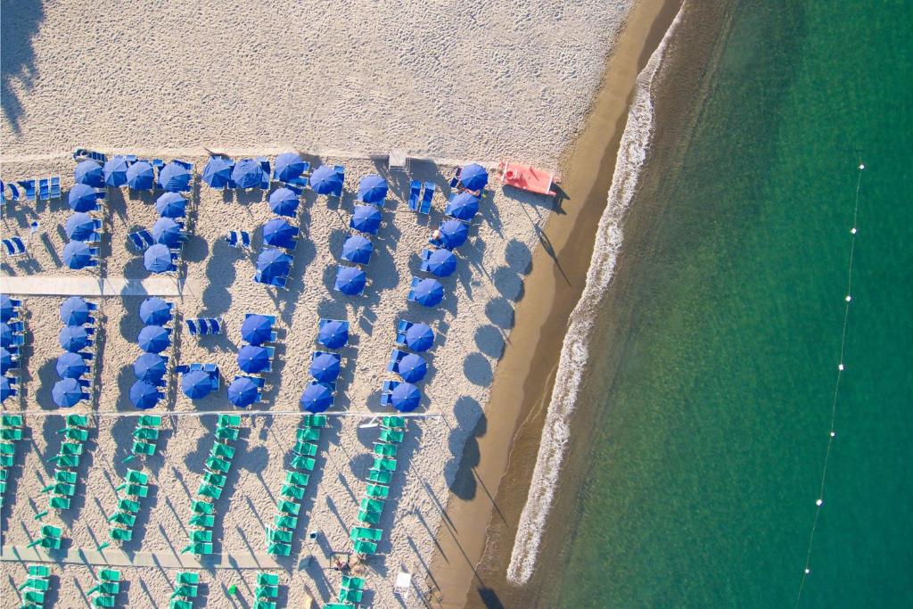 伊斯基亚维拉罗萨泰尔梅酒店的享有海滩上方的遮阳伞和海洋美景