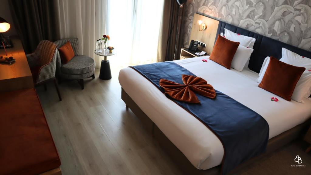 丹吉尔Hotel Ben Batouta - Tanger的酒店客房设有一张大床,上面有弓