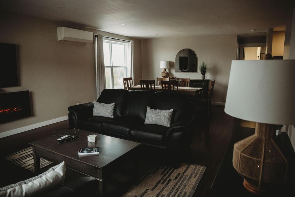 温莎大瀑布河滨套房公寓的客厅配有黑色沙发和桌子