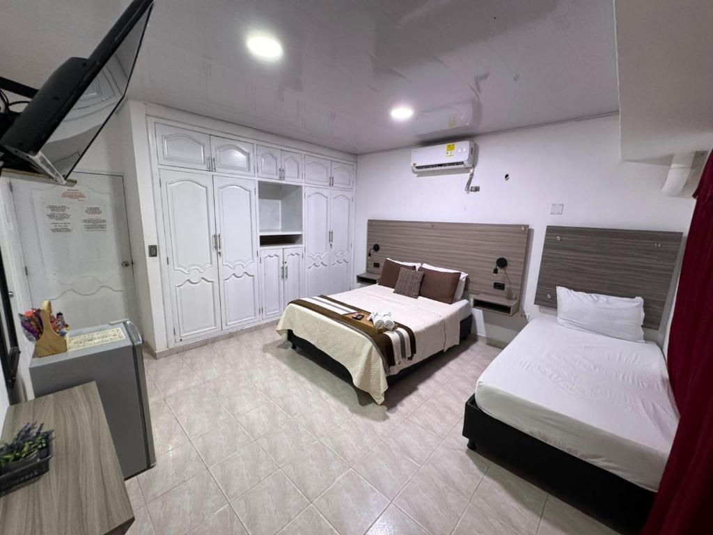 里奥阿查Hotel la Sierra Riohacha II的酒店客房带两张床和厨房