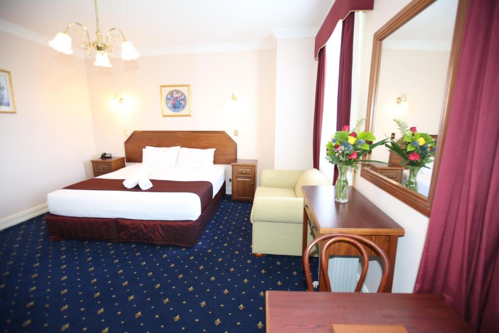 肯图巴皇宫酒店的酒店客房配有一张床铺和一张桌子。