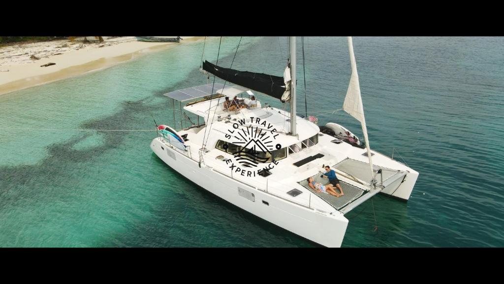 NiagalubirLuxury and Gourmet Catamaran Slow Travel Experience的海滩附近的水中白船