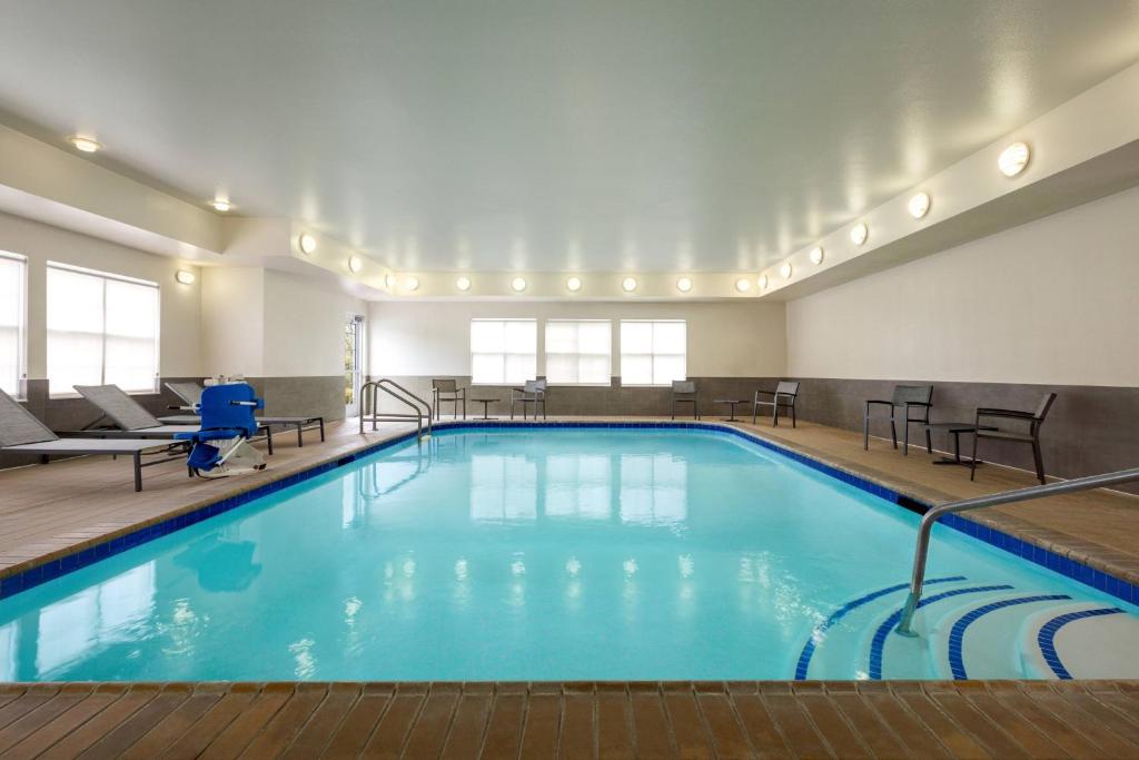 兀兰休斯敦伍德兰兹/市集大街原住客栈的游泳池位于酒店带桌椅的客房内