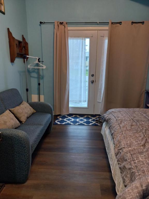 金斯顿Amor Bayridge的带沙发、床和门的客厅