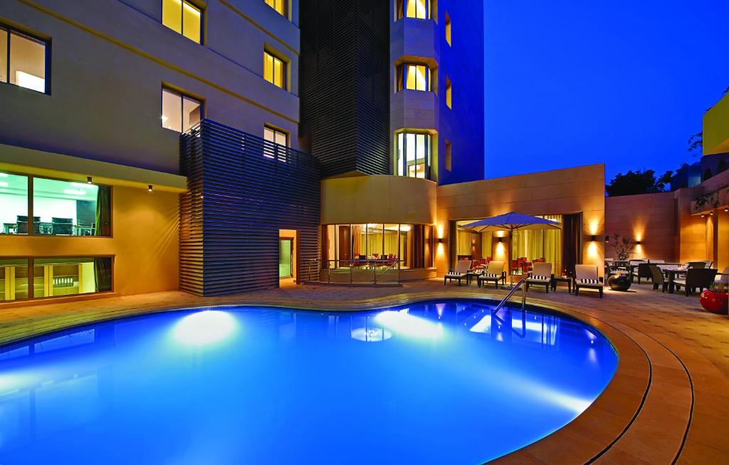安曼安曼公司酒店的一座游泳池,在晚上在建筑物前