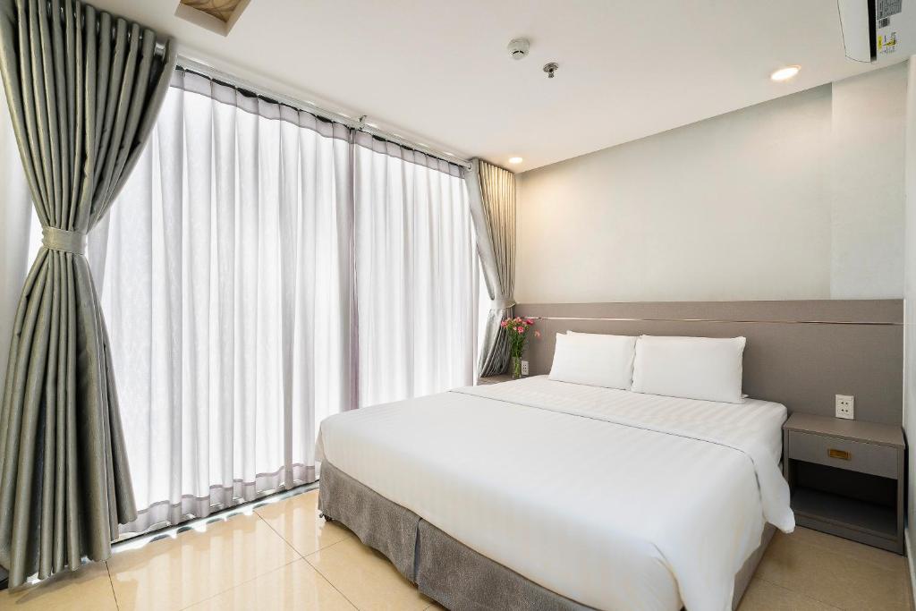胡志明市Lucky Star Hotel Nguyen Trai Q5的卧室设有白色的床和大窗户