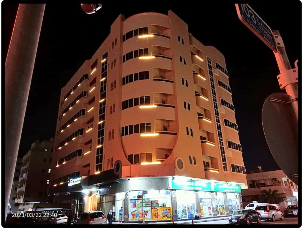 阿吉曼AL MARJAN FURNISHED APARTMENTS的前面有一间商店的高楼