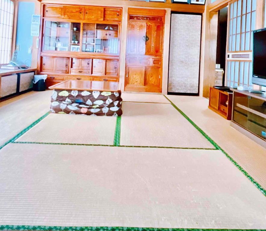 富士吉田市T&T Fujiyama Guest House的客厅配有桌子和电视