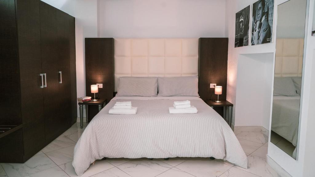 罗马Morin 10 Rome Exclusive Suites的一间卧室配有一张带2个床头柜的大床