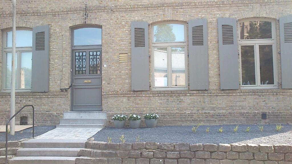 伊普尔De Pastorie - Zillebeke的前面有两株盆栽植物的砖砌建筑
