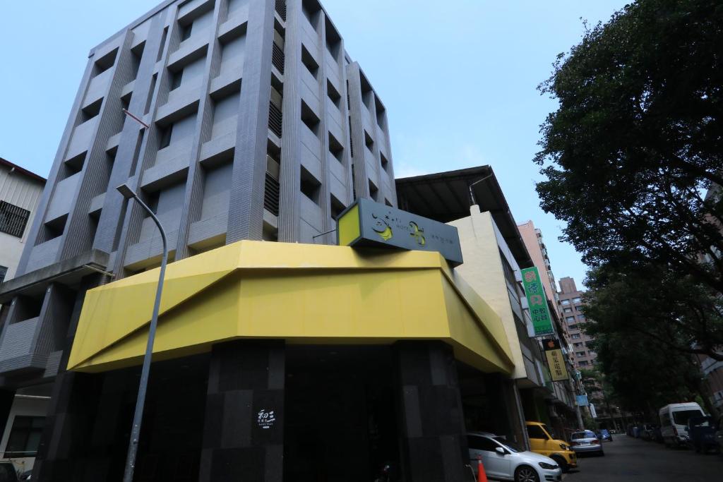 台中市逢甲25行館Fengjia 25 Hotel的前面有黄色遮阳篷的建筑