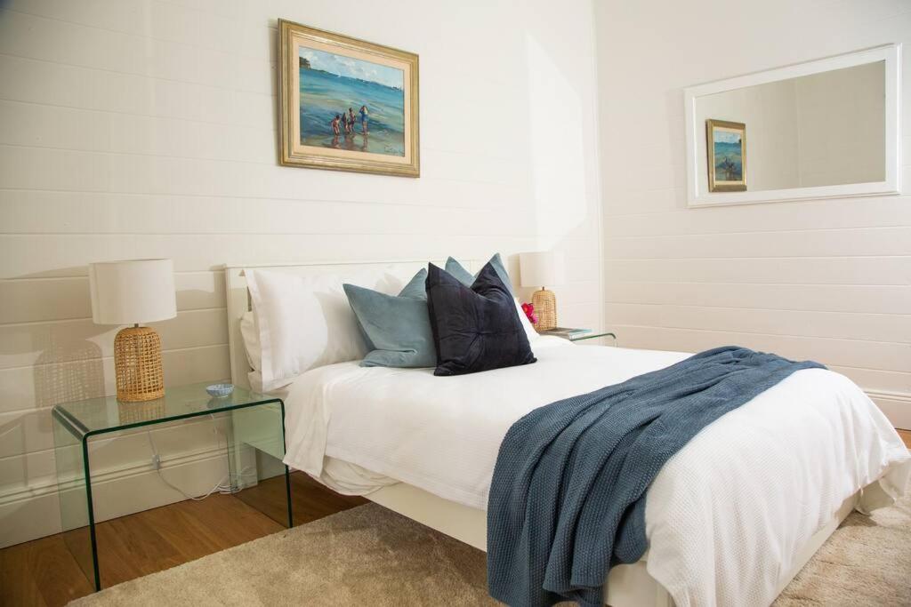 悉尼Balmain Sandstone Cottage的一间卧室配有一张床和一张玻璃桌