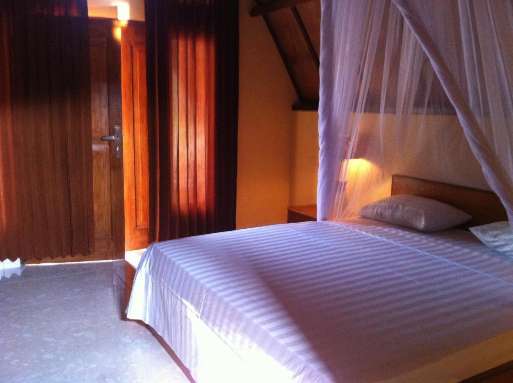 吉利美诺迪诺茵旅馆的一间卧室配有一张带天蓬的白色床
