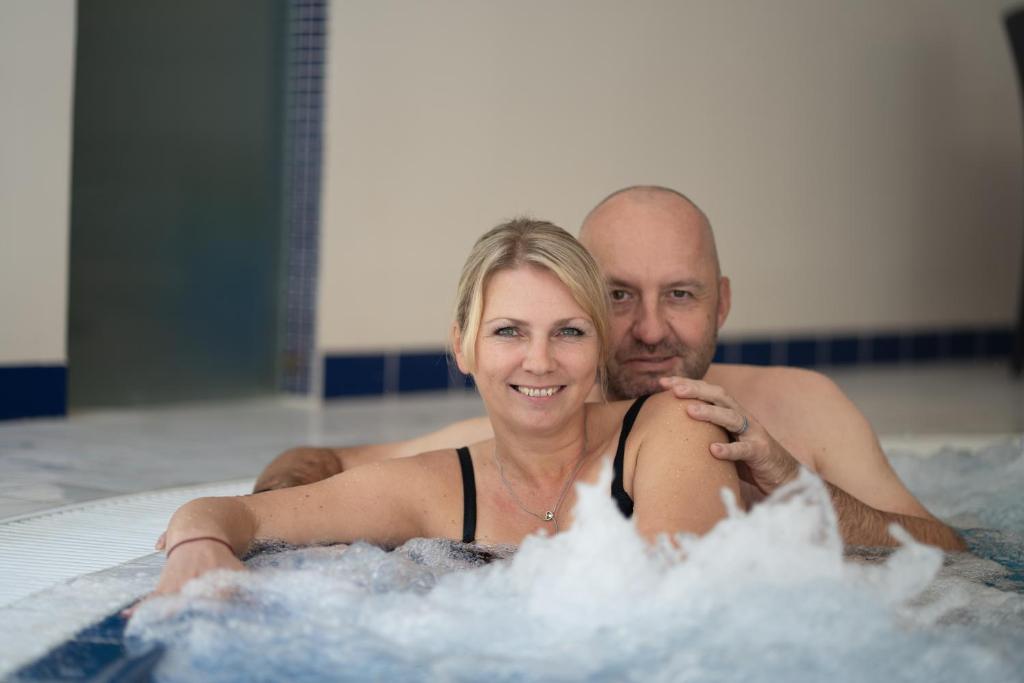 玛丽亚温泉Spa & Wellness Hotel Olympia Marienbad的热水浴池中的男女