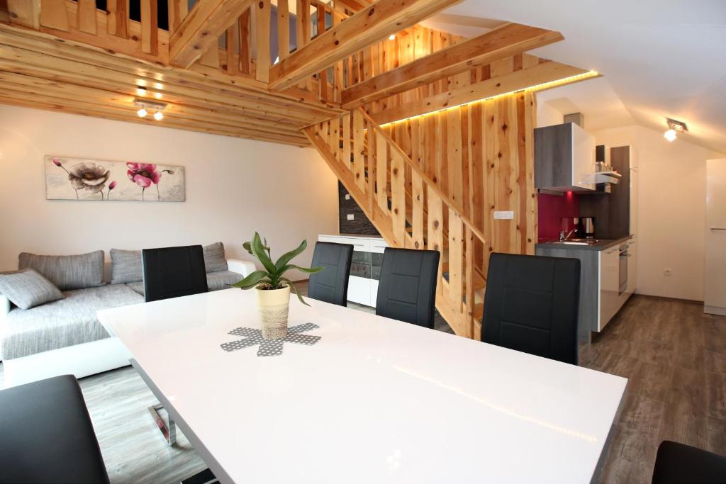 博希尼Apartments Klemenčič的厨房以及带白色桌椅的起居室。