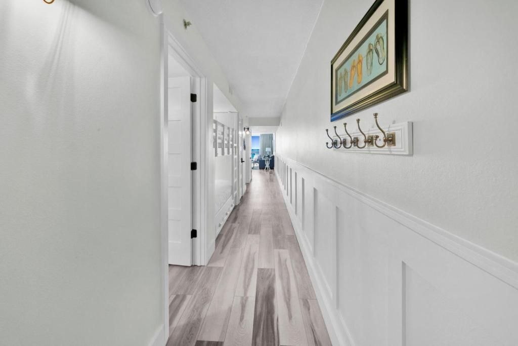 德斯坦Beautiful Updated Pelican Beach Unit!!!的白色的走廊设有白色的墙壁和木地板