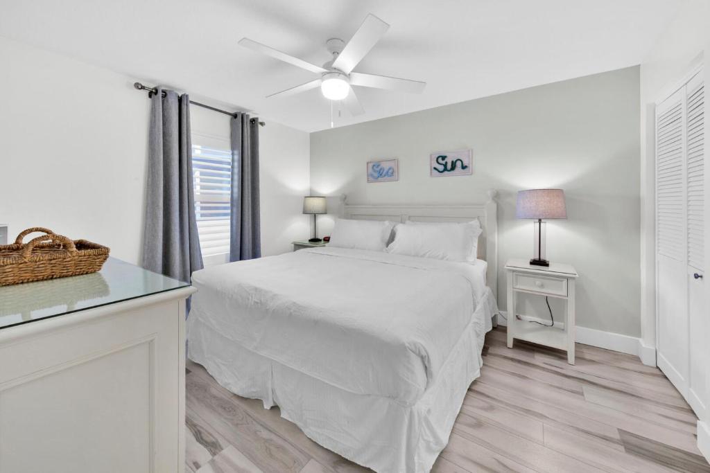 德斯坦Beautiful Updated Pelican Beach Unit!!!的一间带床和窗户的白色卧室