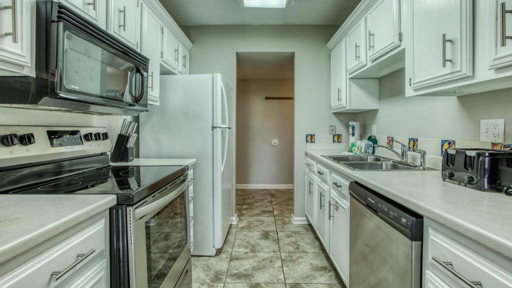 德斯坦Cozy renovated ground floor unit - Golf Villa - on the Golf Course的厨房配有白色橱柜和白色冰箱