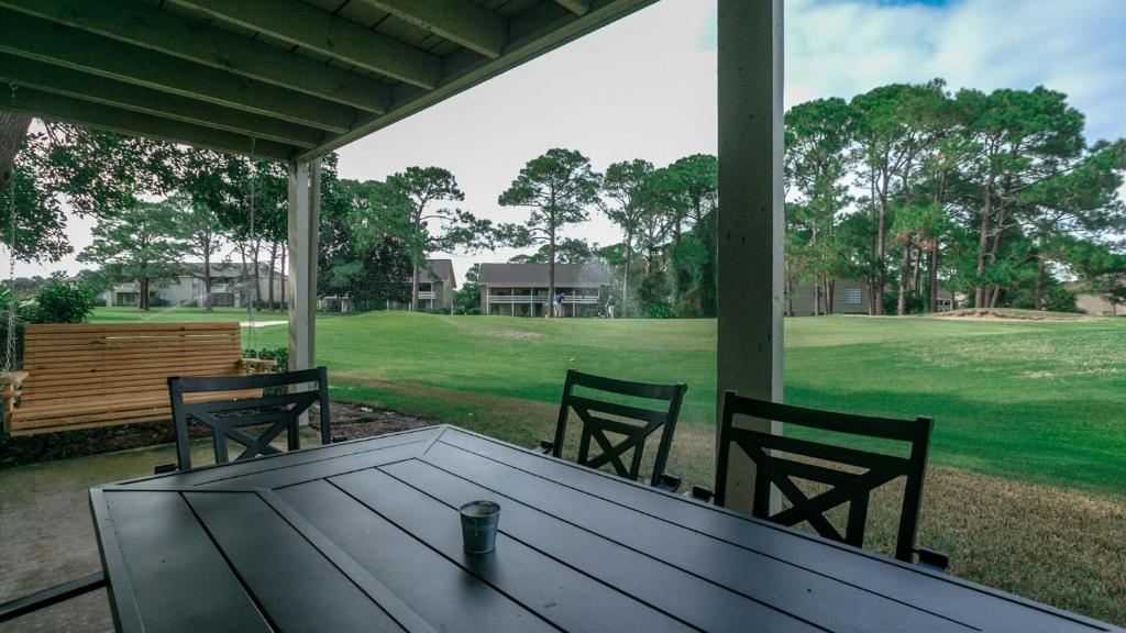 德斯坦Cozy renovated ground floor unit - Golf Villa - on the Golf Course的享有田野景致的门廊上的桌椅