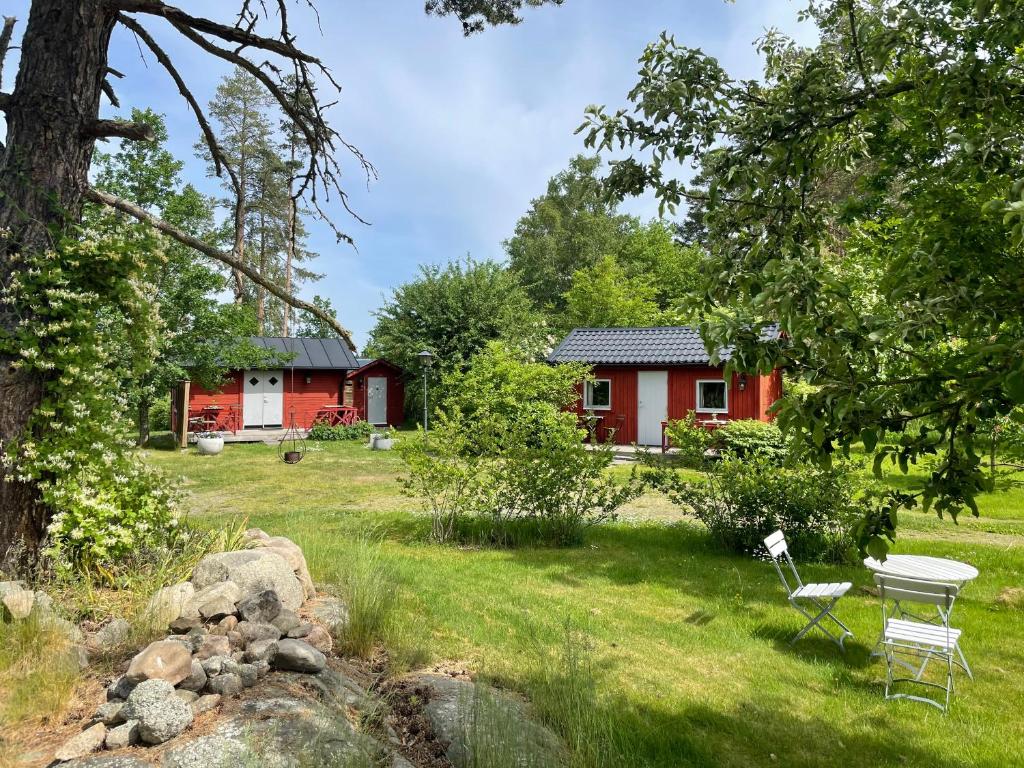 格兰纳Södra Kärr 4的一间红色小屋,在院子里配有桌椅